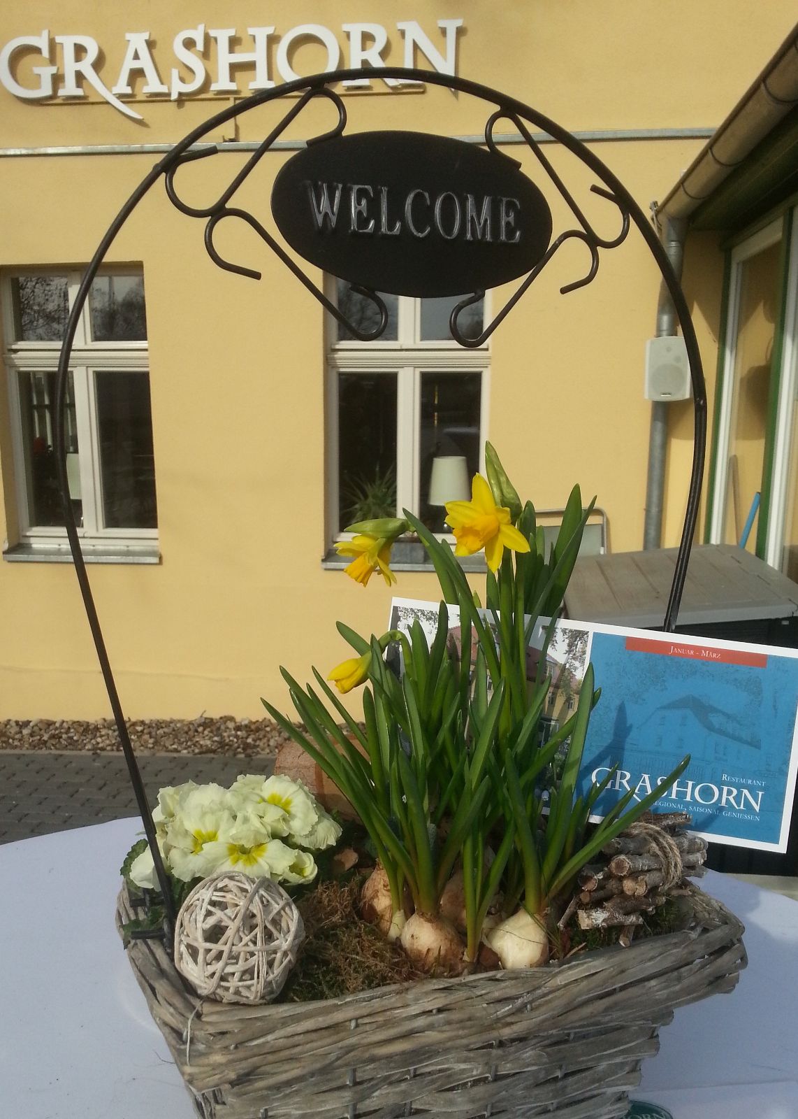 Blumendekoration mit Welcome-Schild vor dem Restaurant Grashorn
