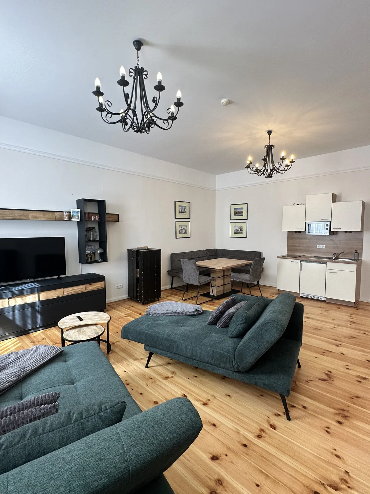Wohnbereich mit Sofa, Tisch und offener Küche im Apartmenthaus Gutenberg 78